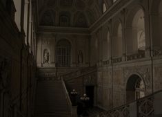 an old building with stairs leading up to the second floor and paintings on the walls