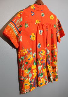 "Vintage, 1960's-1970's, Artistic Product, orange psychedelic floral t-shirt blouse. In like-new condition with tags. Women's Small Length, 29\" Underarm to underarm, 19\" Sleeves, 9.5\"" Spring Bold Print Orange Tops, Retro Orange Printed Shirt, Orange Cotton Top With Retro Print, Retro Orange Printed Top, Orange Retro Print Summer Shirt, Summer Orange Shirt With Retro Print, Summer Orange Tops With Bold Print, Orange Bold Print Summer Top, Orange Tops With Bold Print For Summer