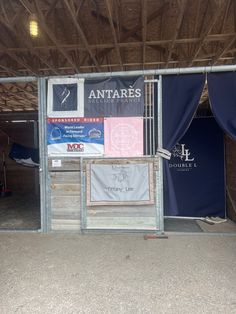 the inside of a horse stable with blue and white banners on it's walls