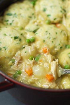 a pot filled with chicken and dumplings on top of a stove