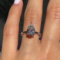 a woman's hand with a ring on it and a diamond in the middle