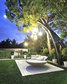 a swing chair sitting on top of a white rug in the middle of a yard