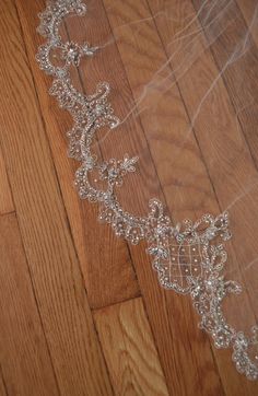 a wedding veil laying on top of a wooden floor