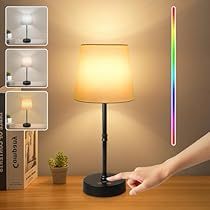 a person is pointing at a colorful light on a table next to a book shelf