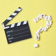 popcorn spilled out of a movie clapper next to a pair of scissors