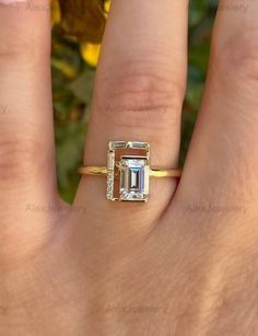 a woman's hand with a ring on it and an emerald stone in the middle