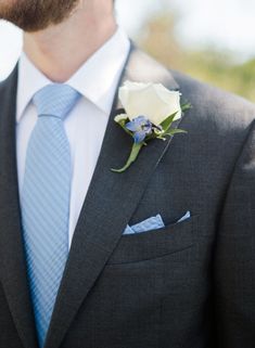 a man in a suit and tie with a boutonniere on his lapel