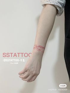 a woman's arm with a red line tattoo on her left wrist and right hand