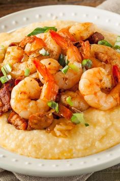 a white plate topped with shrimp and grits