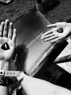 two people holding their hands up in front of a book