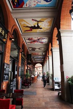 the walkway is lined with colorful paintings on the ceiling