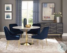 a dining room table with blue chairs and a white rug on the floor in front of it