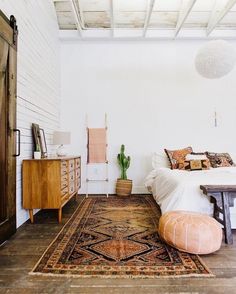 a bed room with a neatly made bed and lots of color samples on the wall