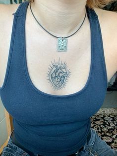 a woman with a heart tattoo on her chest