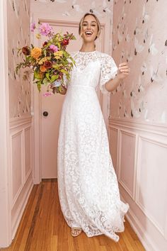 a woman in a white dress holding a bouquet of flowers