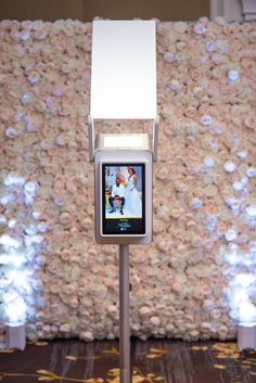 an electronic device is on display in front of a flower wall