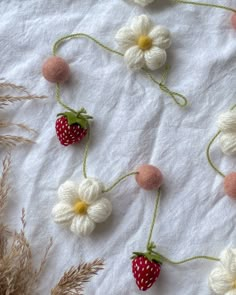 crocheted strawberries and daisies on a white sheet