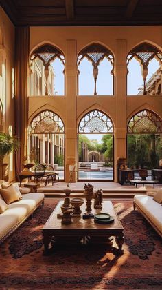 a living room with couches and tables in front of an arched doorway that leads to a pool