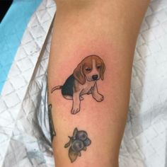 a small dog tattoo on the right arm and leg, with a little puppy sitting next to it