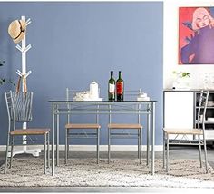 a dining room with blue walls and white furniture, including a glass top table surrounded by metal chairs