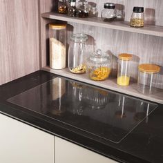 the kitchen counter has jars and containers on it, along with other items such as spices