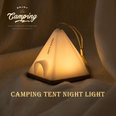 a white lamp sitting on top of a bed with the words camping tent night light