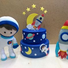 three small toys are sitting next to each other in front of a wall with stars and moon on it