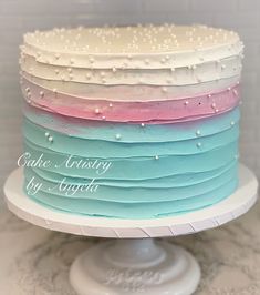 there is a multi layer cake on top of a white plate with pearls and icing