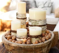 a wooden bowl filled with candles and nuts