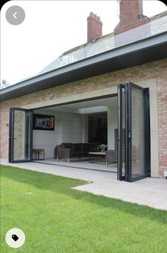 an open patio area with sliding glass doors on the outside and brick building in the background