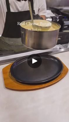 a person cooking food in a pan on top of a stove