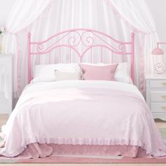 a pink bed with white sheets and pillows