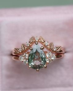 an engagement ring with a pear shaped green and white diamond