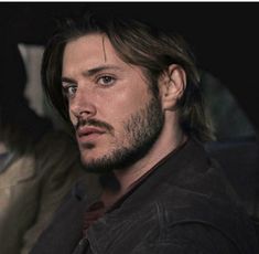 a man with long hair sitting in a car