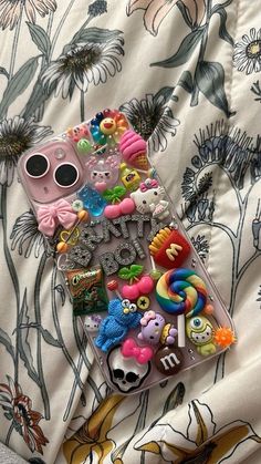 there is a phone case that has many different things on it, including buttons and stickers