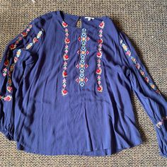 Long Sleeved Embroidered Blouse. Keyhole Opening. Never Worn. Pet And Smoke Free Home Casual Blue Peasant Top With Floral Embroidery, Casual Blue Top With Embroidered Neckline, Blue Long Sleeve Blouse With Floral Embroidery, Casual Blue Embroidered Neckline Top, Casual Blue Embroidered Top With Neckline Detail, Blue Peasant Top With Floral Embroidery For Spring, Casual Blue Embroidered Peasant Top, Blue Floral Embroidered Peasant Top For Spring, Blue Floral Embroidery Peasant Top For Spring