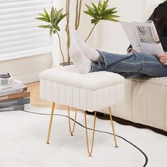 a woman sitting on a couch reading a magazine