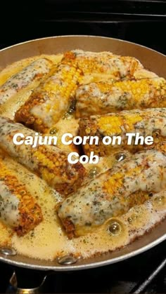 a frying pan filled with corn on the cob covered in cheese and sauce