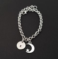 "Personalized Antique Silver Moon Bracelet! A detailed crescent moon and star charm on a lovely chain bracelet makes the perfect gift for you or your best friend. The moon bracelet charm is made from zinc alloy and measures 10 x 14 mm. The bracelet is high quality zinc alloy and measures 8.5\". The moon charm bracelet can be personalized with a .5\" silver plated disc stamped with the initial of your choice. The charm and initial disc are connected to the bracelet with sturdy split rings that wi Celestial Charm Bracelet With Moon Charm As A Gift, Celestial Moon Charm Bracelet As Gift, Celestial Moon Charm Bracelet For Gift, Adjustable Moon Charm Bracelet, Celestial Bracelet With Moon Charm, Celestial Round Bracelet With Moon Charm, Celestial Crescent Bracelets With Moon Charm, Metal Charm Bracelet With Moon Charm As A Gift, Celestial Crescent Silver Bracelets