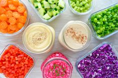 six containers filled with different types of vegetables and dips on top of a table