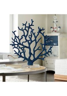 a blue coral sculpture sitting on top of a table in front of a white wall