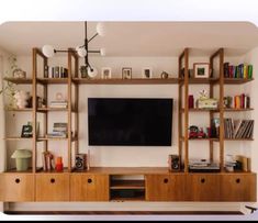 an entertainment center with bookshelves and a flat screen tv mounted on the wall