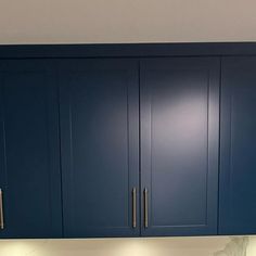 a kitchen with blue cabinets and white counter tops