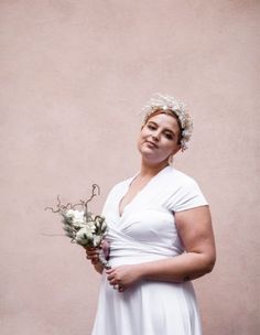 a woman in a white dress holding flowers