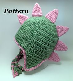 a crocheted green hat with pink ears and spikes on it's brim