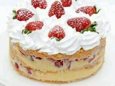 a white plate topped with a cake covered in frosting and strawberries on top