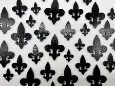 a bunch of black fleur de lis on a white background with some smaller fleur de lis in the middle