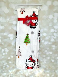 a hello kitty towel hanging on a rack with christmas tree and snowflakes in the background