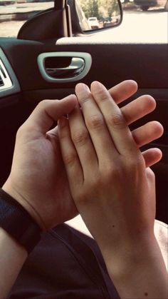 a woman is holding her hands together in the car