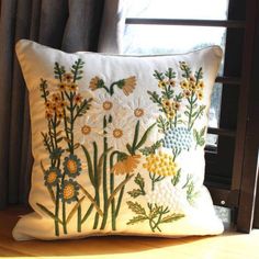 a white pillow sitting on top of a window sill next to a wooden frame